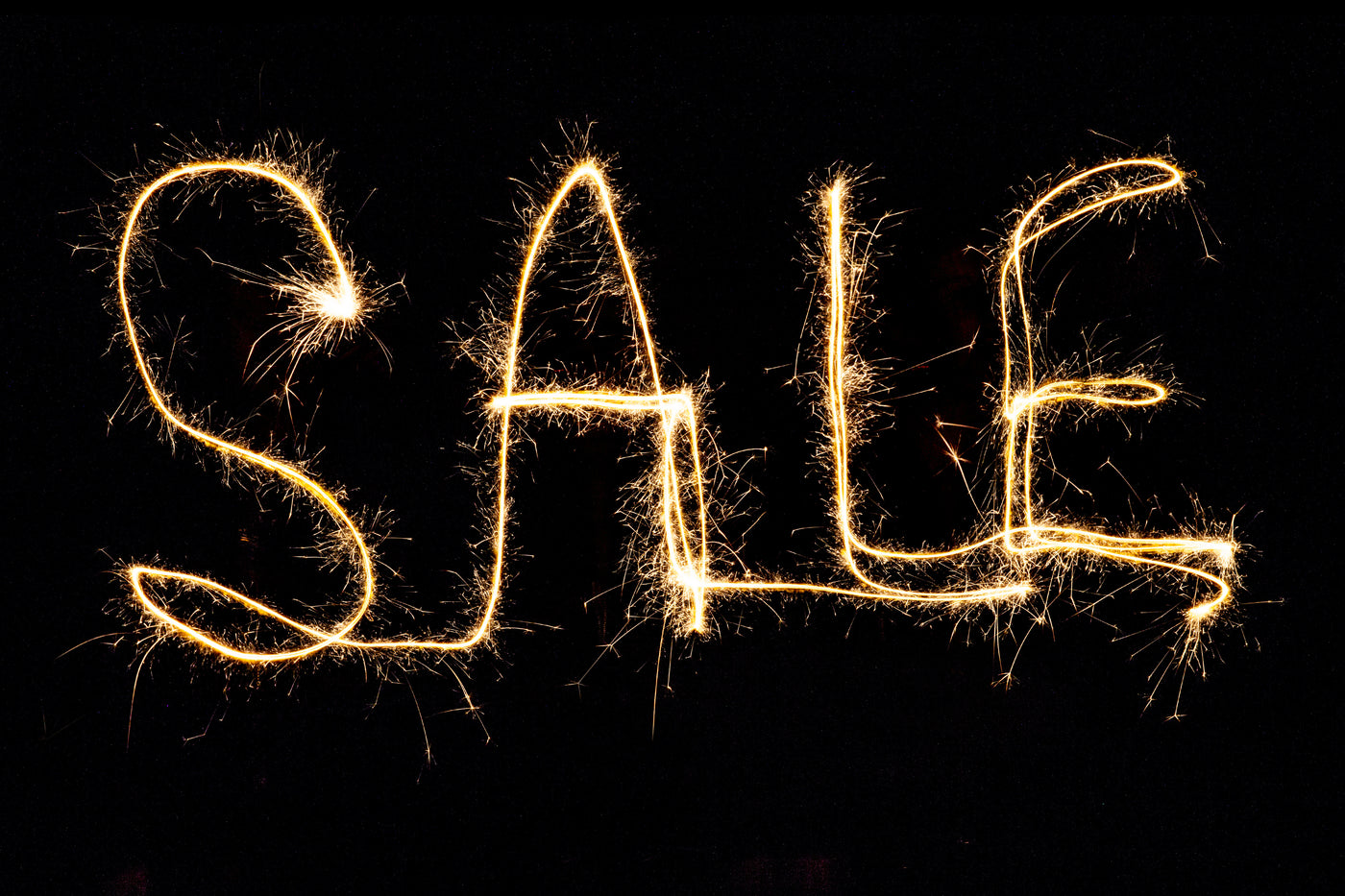 Banner with SALE written in sparkler type fireworks letters, black background